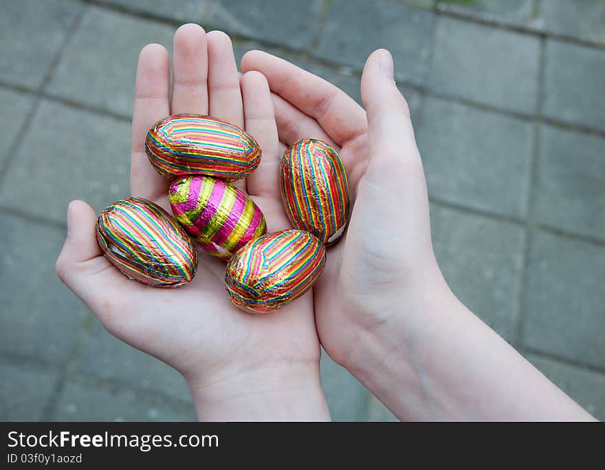 Hands of a teenager holding a hand full of Easter suprise eggs. Showing of the Easter eggs he found during the Easter hunt. Hands of a teenager holding a hand full of Easter suprise eggs. Showing of the Easter eggs he found during the Easter hunt.