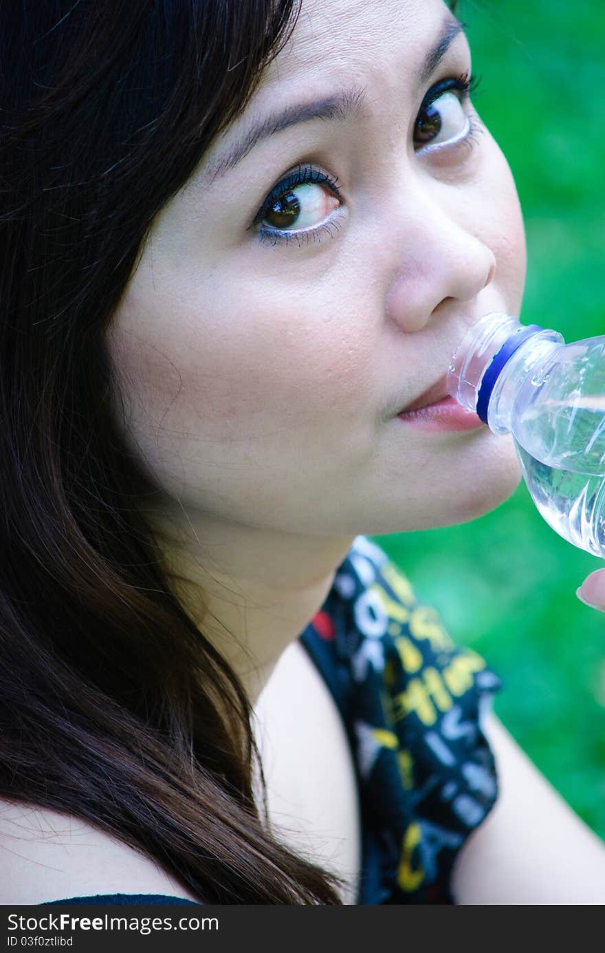 A pretty girl is drinking mineral water