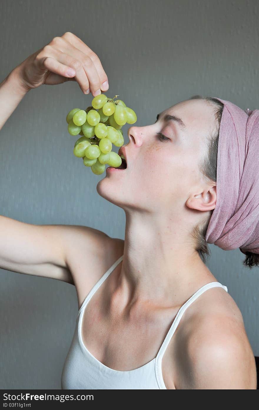 Young girl is eating green grape. Young girl is eating green grape