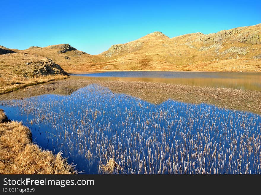 A deep blue mountain lake called Tarn at Leaves  in the English Lake District National Park