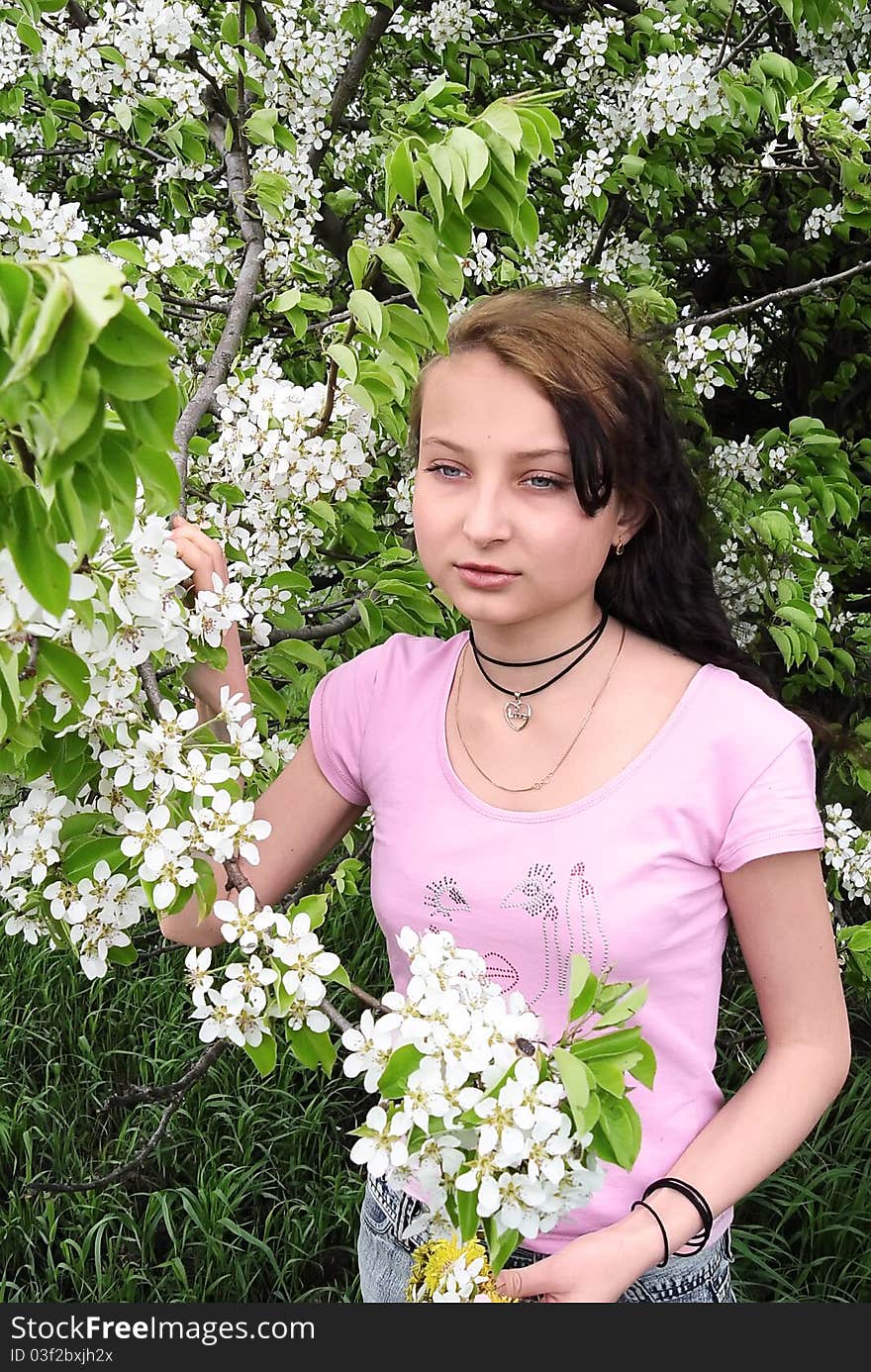 Girl among the blossoming apple trees