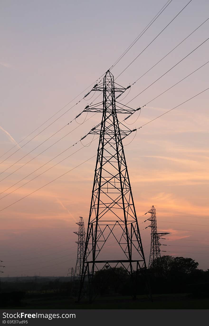 Electricity pylons on a freeway at Dusk time, little grain added to the sky to prevent banding and to give a nicer blending effect. Electricity pylons on a freeway at Dusk time, little grain added to the sky to prevent banding and to give a nicer blending effect