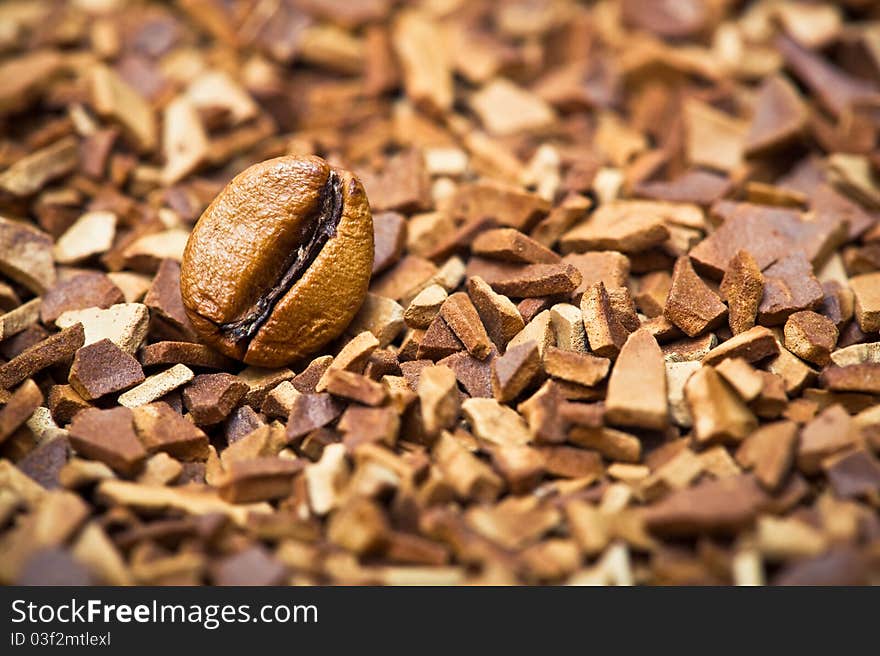 Closeup of a coffee bean and soluble coffee