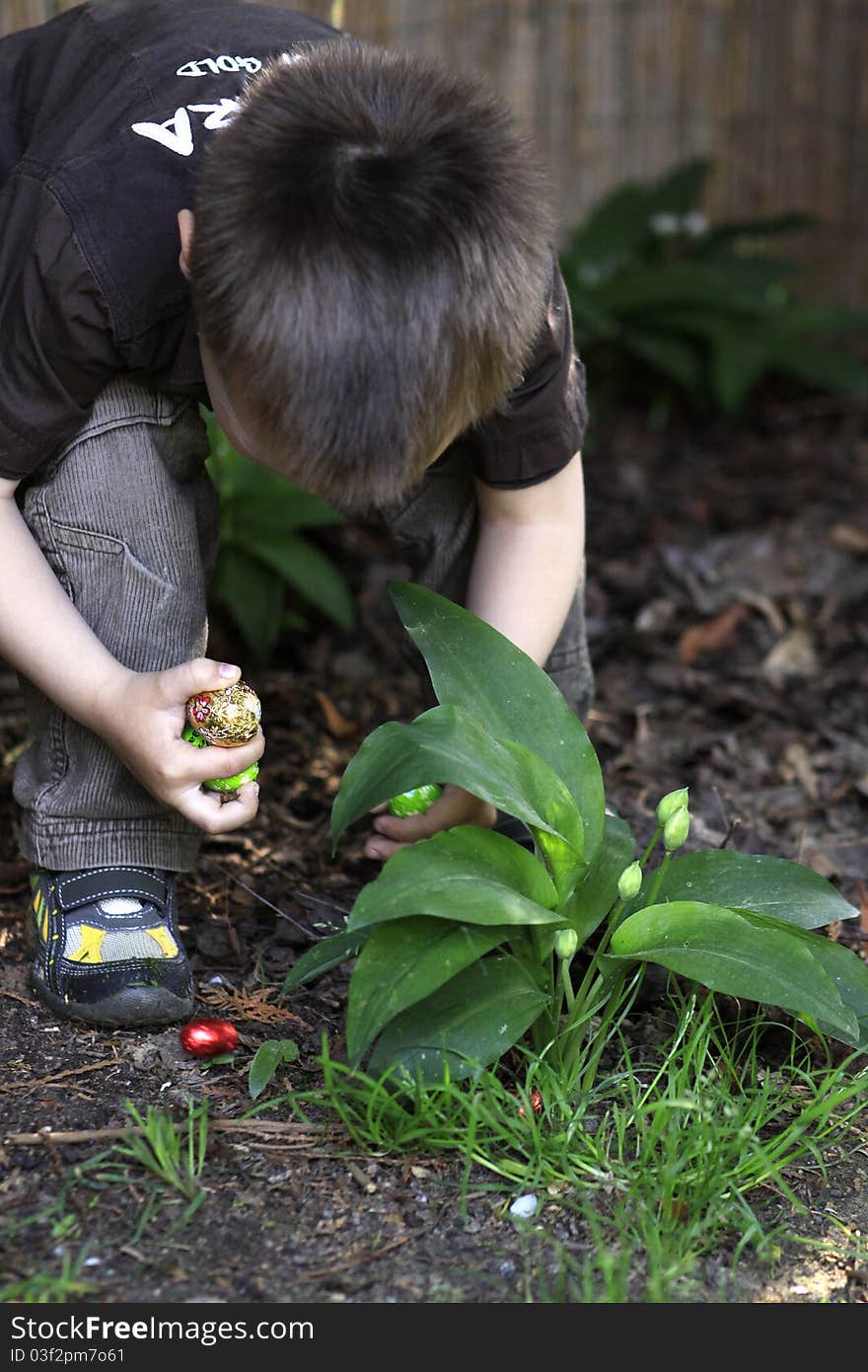 Young white boy searching for easter eggs in the garden