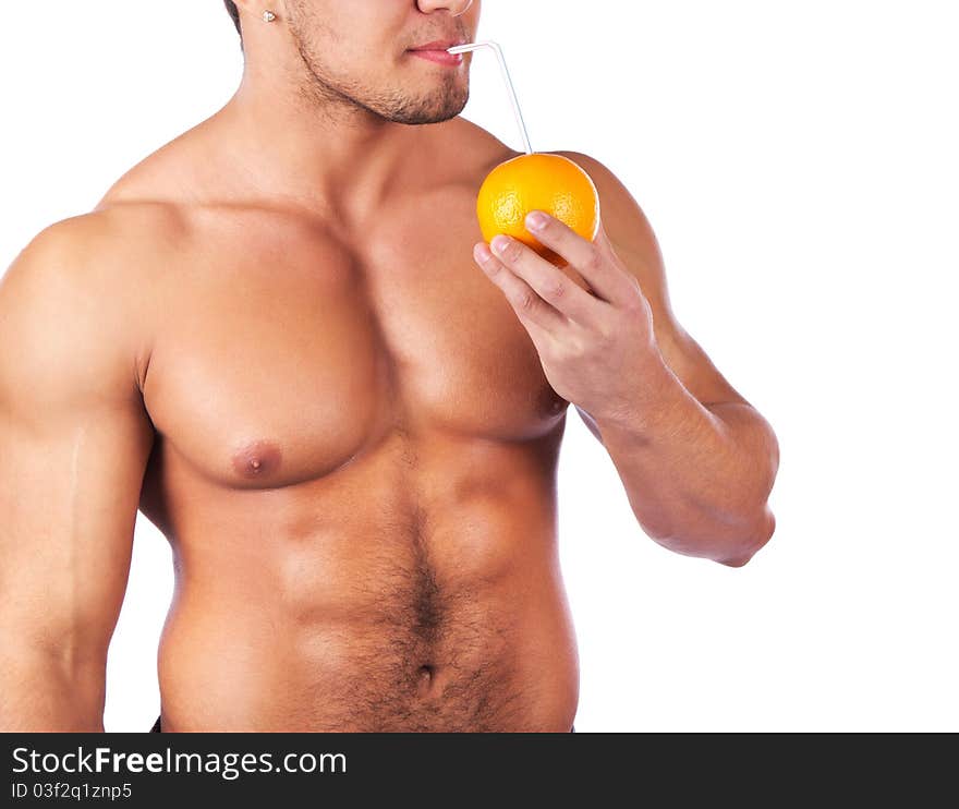 Man is holding an orange and drinking. Man is holding an orange and drinking