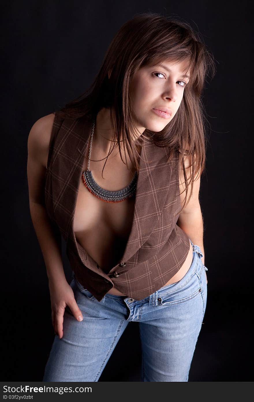 An image of a pretty, young woman in a low-cut vest leaning towards the camera provocatively and making eye contact with the viewer. An image of a pretty, young woman in a low-cut vest leaning towards the camera provocatively and making eye contact with the viewer