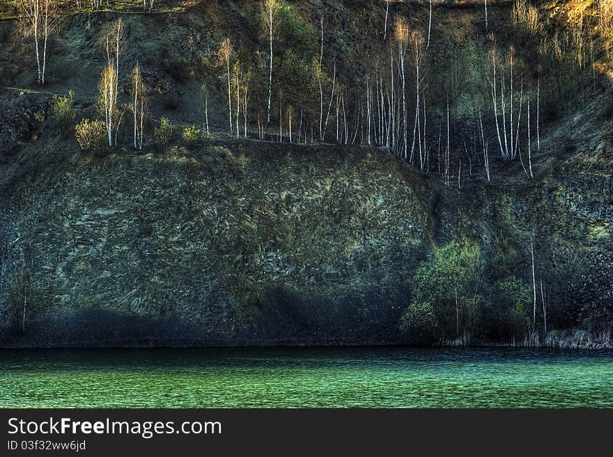 Rock cliff with the water surface at sunset. Rock cliff with the water surface at sunset