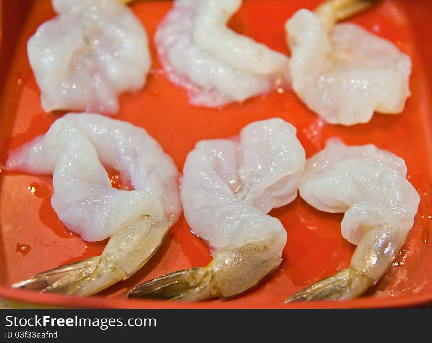 Choped raw shrimp on red plate ready to eat or cooking