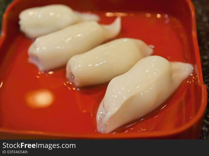 Raw squid stuffed with minced pork ready to cook on dish