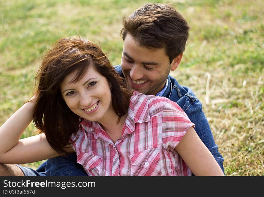 A young couple in love in a park hugging and kissing playing