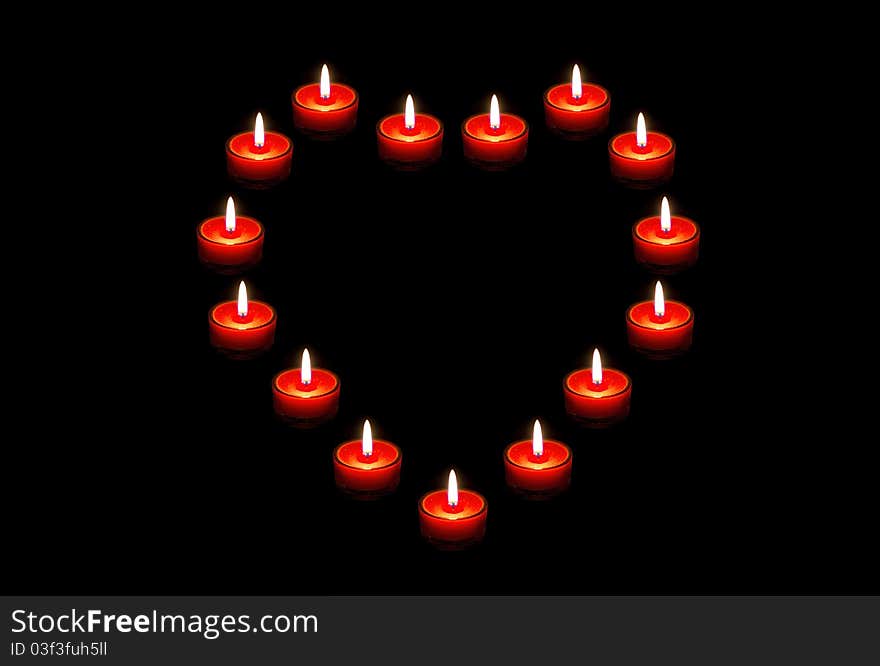 Heart of red candles on a black background. Heart of red candles on a black background