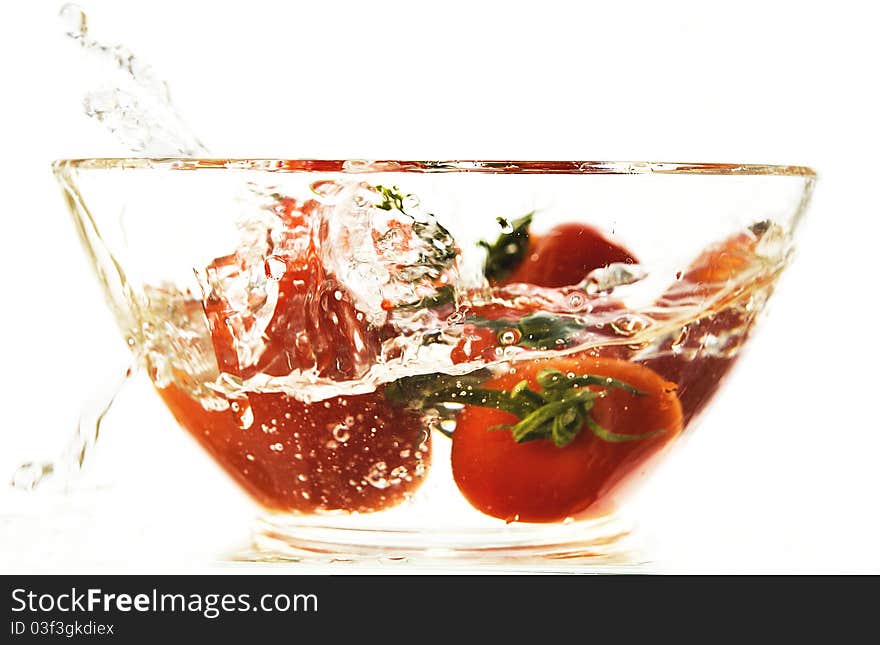 Red tomatoes in a plate with water on the white isolated background