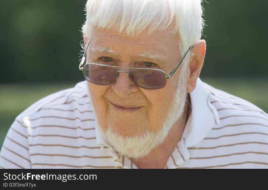 Old man wearing glasses outside during the day. Old man wearing glasses outside during the day