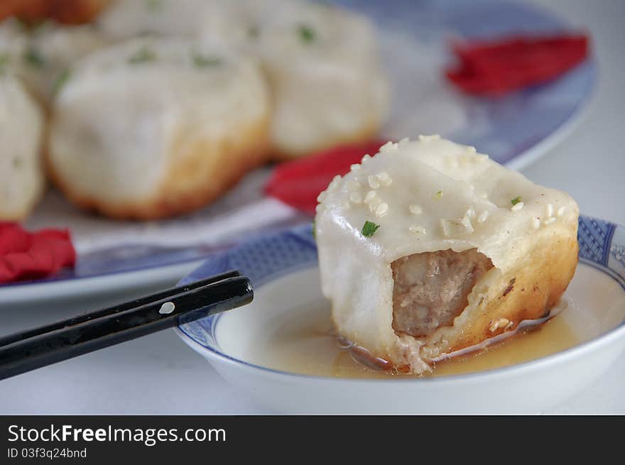 Chinese characteristic fried bun on a porcelain plate. Chinese characteristic fried bun on a porcelain plate