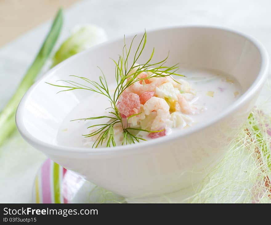 A bowl of cold soup with vegetables and shrimp