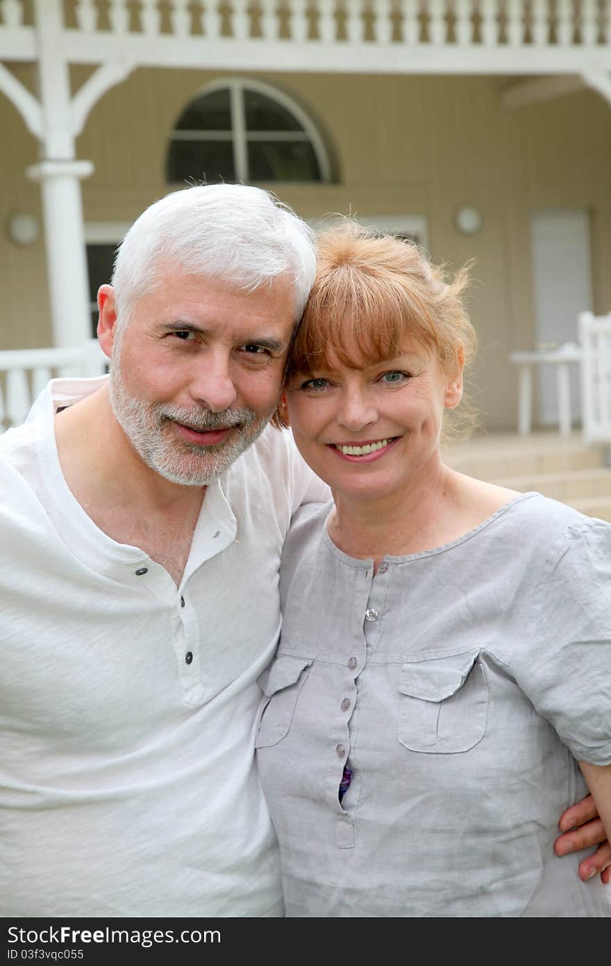 Portrait of senior couple standing in front of their home. Portrait of senior couple standing in front of their home