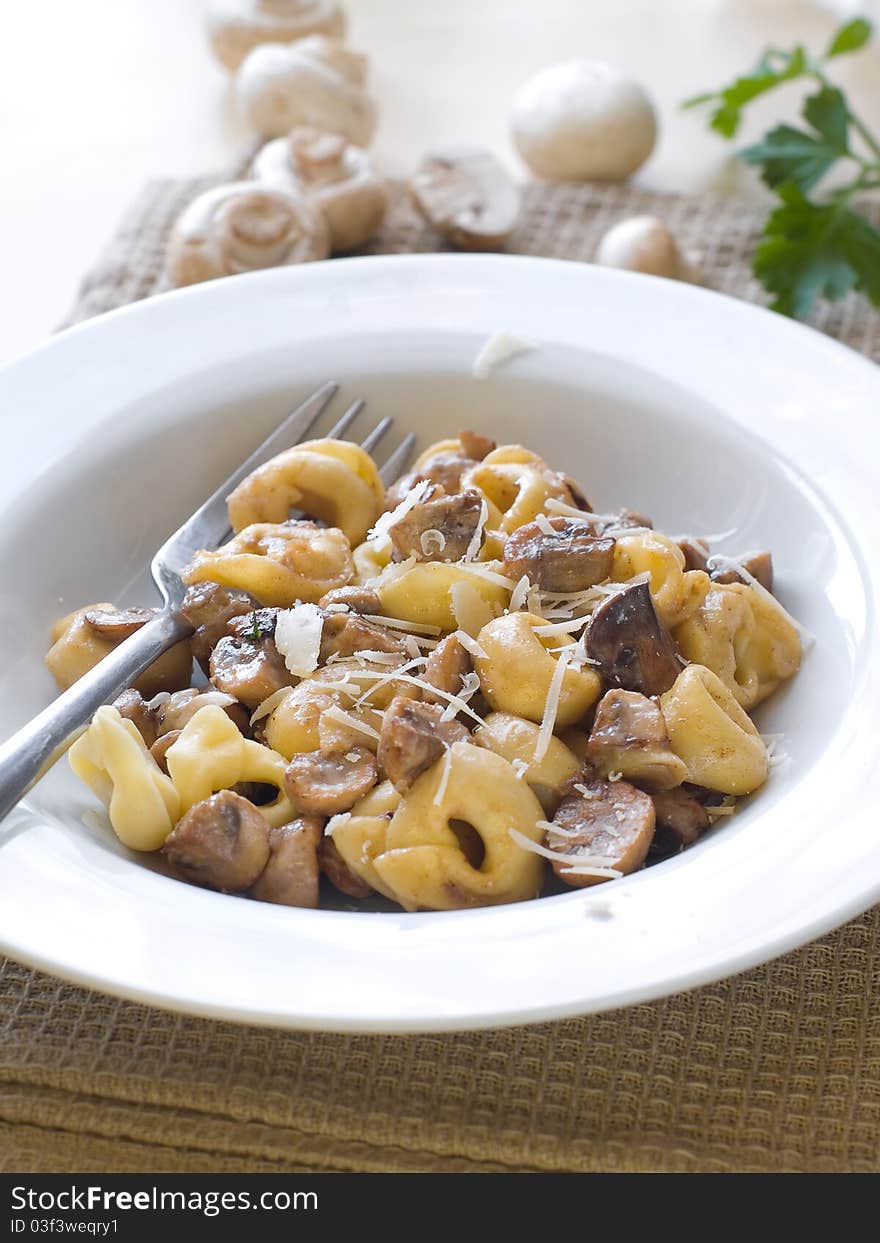 Tortellini with mushrooms sauce and cheese, selective focus