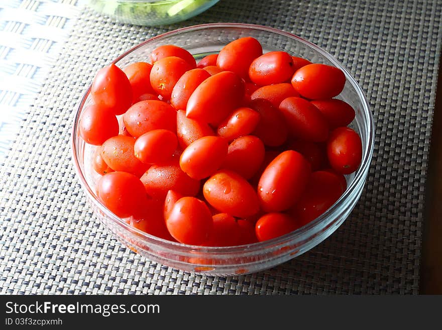 Many deep red tomatoes with green stems, full with antioxidants