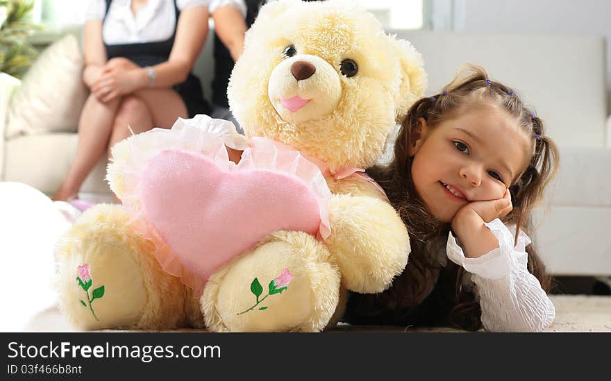 Little girl is hugging big bear