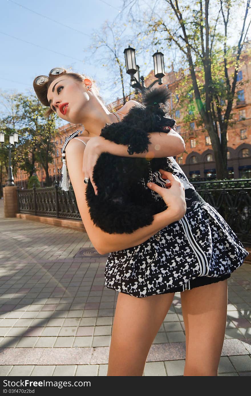 A girl with a dog standing on the street