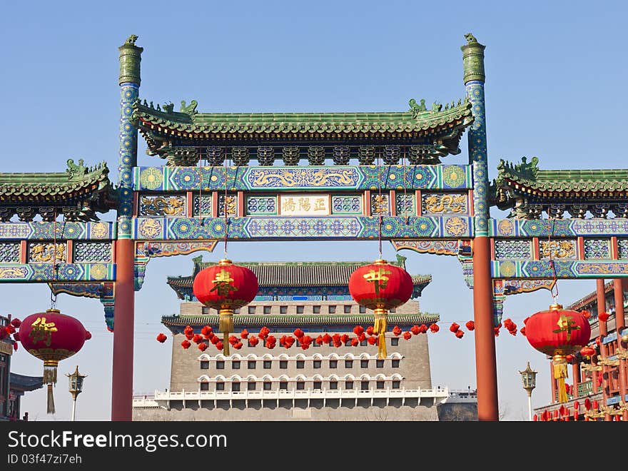 Chinese stone decorated archway and ancient city tower of Beijing in Chinese New Year.