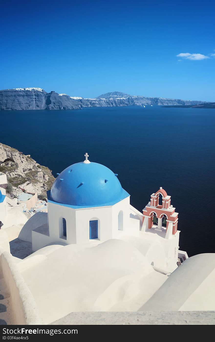 Orthodox church at Oia (Ia) village with Fira town and cruise ships in the distance, (Santorini). Orthodox church at Oia (Ia) village with Fira town and cruise ships in the distance, (Santorini).