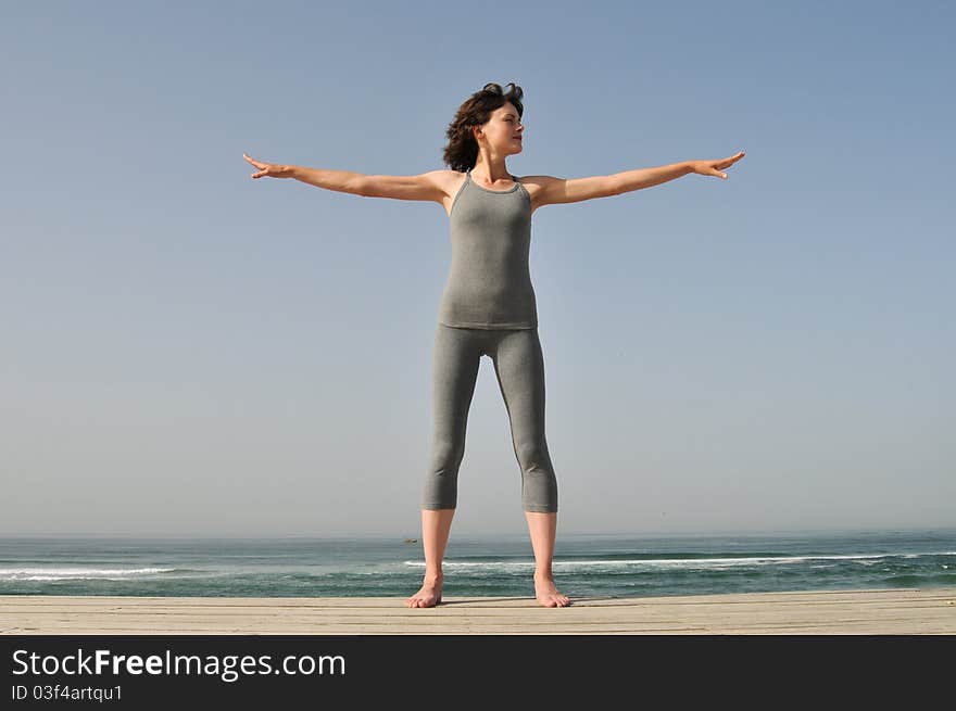 Young woman doing exercises on the beach