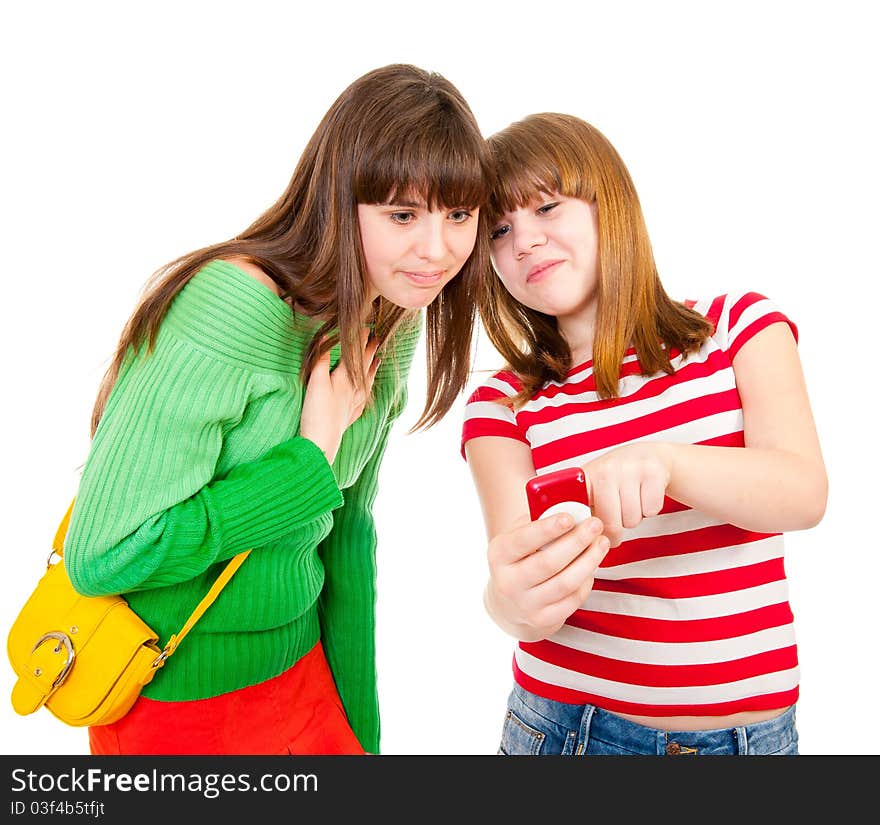 Two schoolgirls watching something in the mobile phone isolated