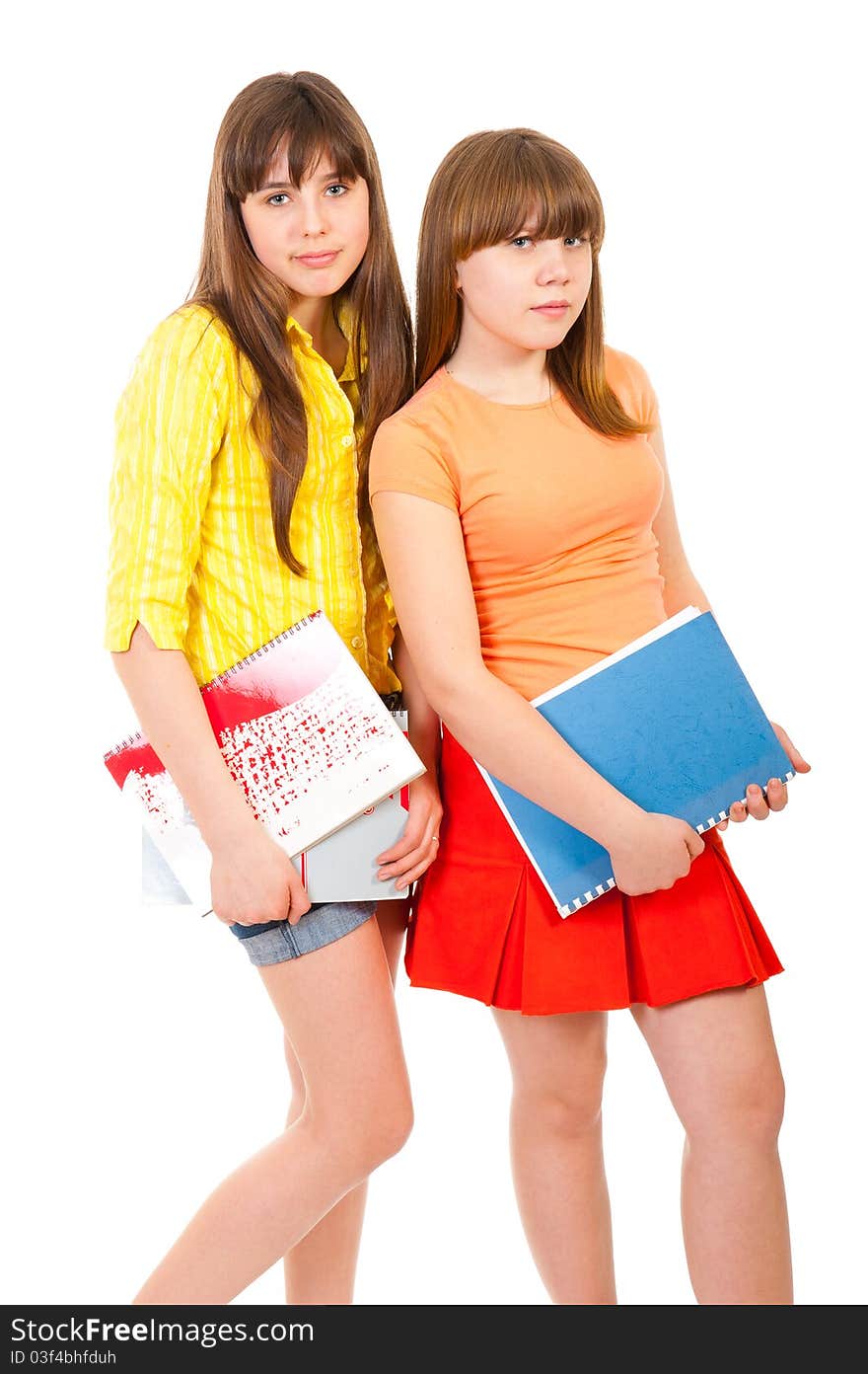 Two schoolgirls teenagers with notebooks isolated over white