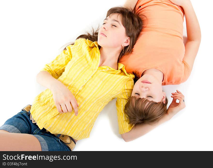 Two teen girls lie side by side isolated on white