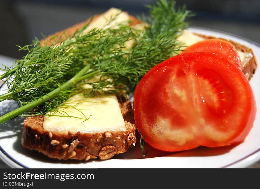 Tasty cheese sandwich, tomato and fresh dill on a plate, lunch. Tasty cheese sandwich, tomato and fresh dill on a plate, lunch