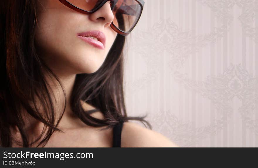 woman in sunglasses on a floral wallpaper background. woman in sunglasses on a floral wallpaper background