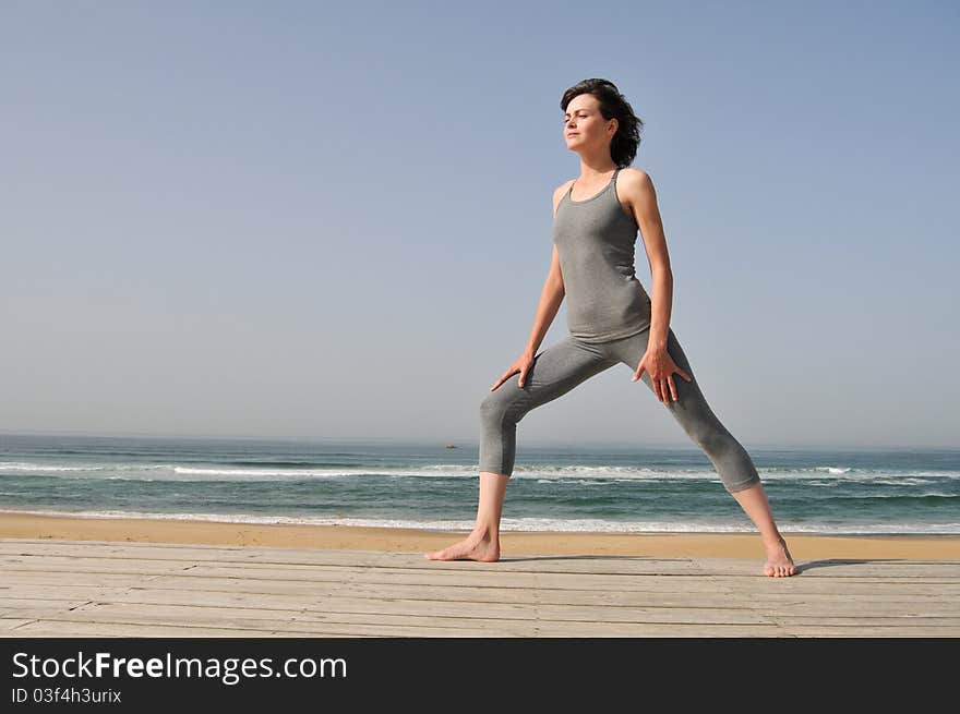 Young Woman Doing Exercises On The Beach