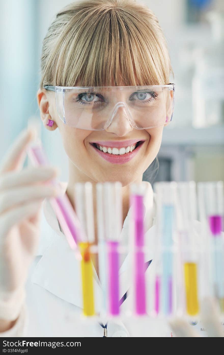 Female Researcher Holding Up A Test Tube In Lab