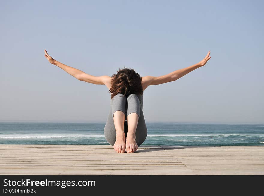 Young woman doing exercises on the beach