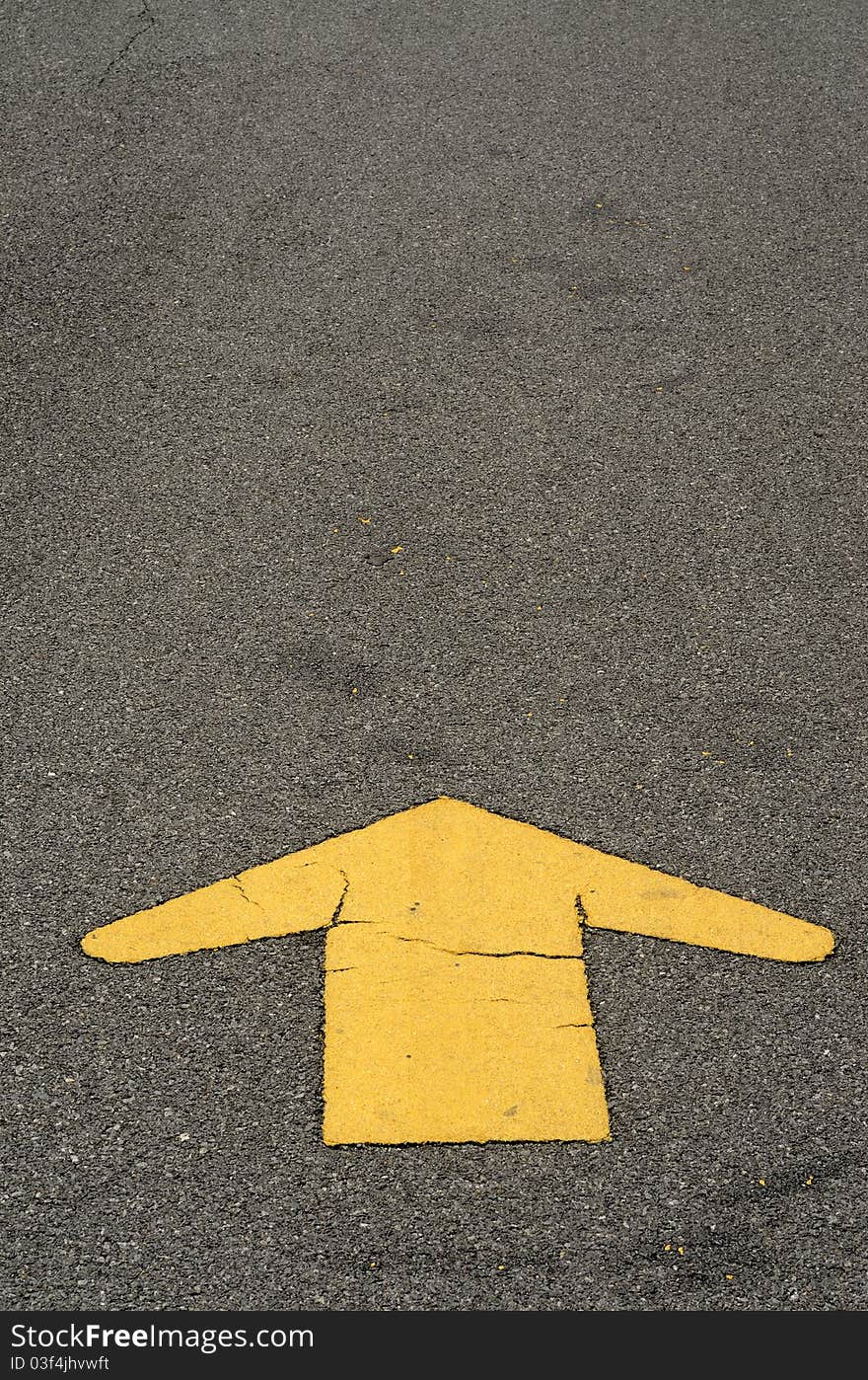 Yellow line arrow road sign on asphalt.