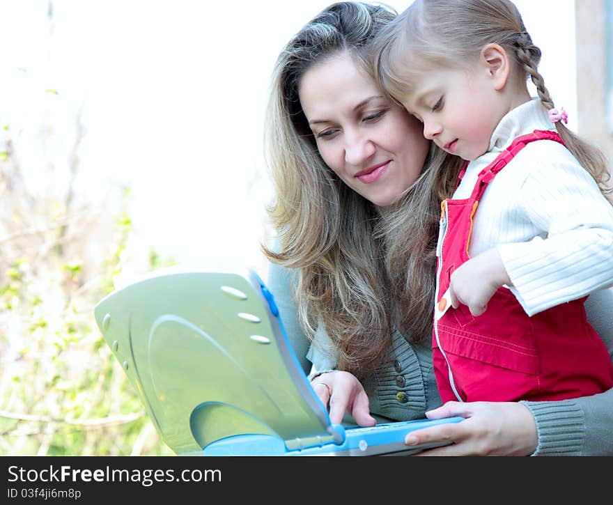 Mother and daughter outdoor with notebook