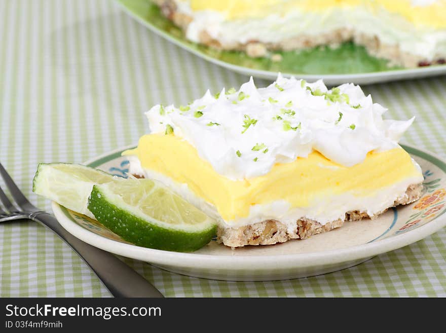 Lemon lime pudding dessert topped with whipped cream and lime slices on a plate