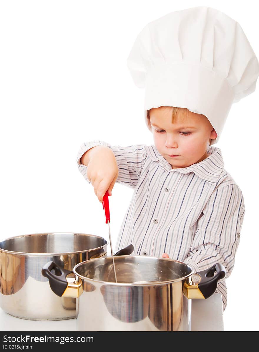 A funny cute boy is portraying a cook. isolated on a white background. A funny cute boy is portraying a cook. isolated on a white background