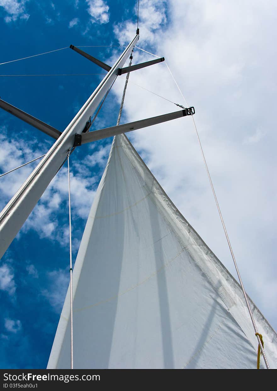 Yacht Mast With The Sail On The Blue Sky