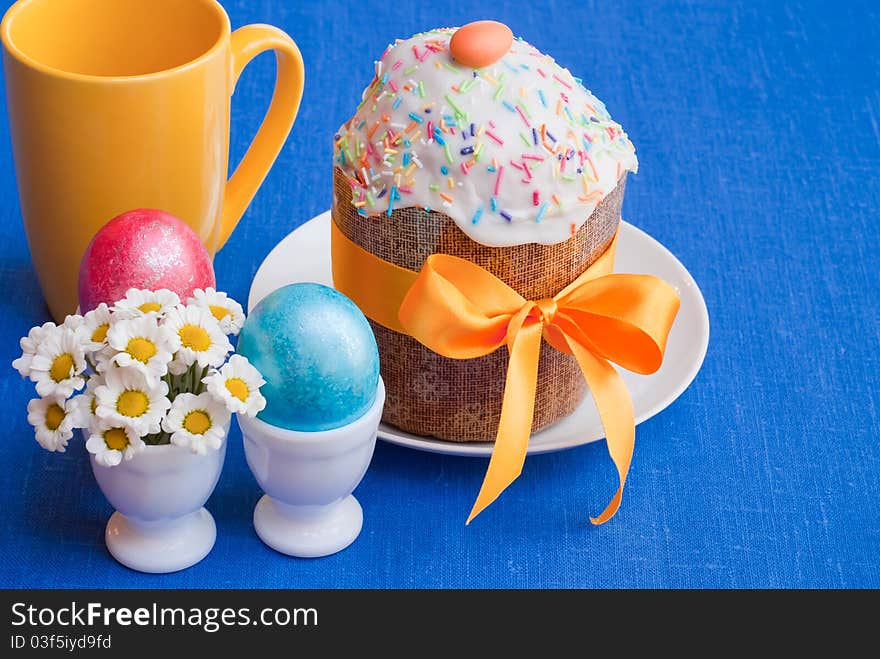 Easter: cake and eggs on blue linen tablecloth, selective focus. Easter: cake and eggs on blue linen tablecloth, selective focus.