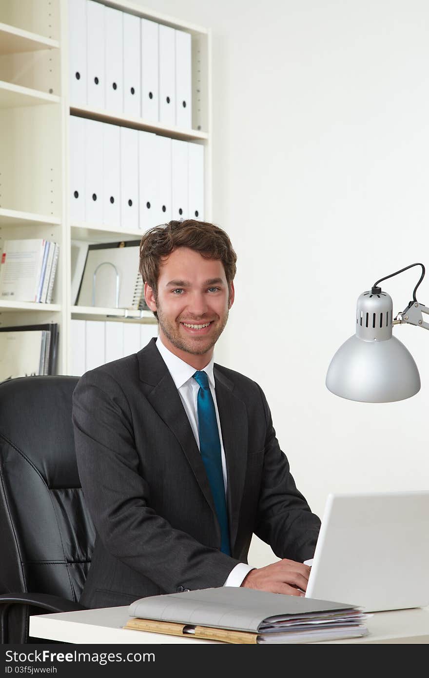 Business man in office with laptop