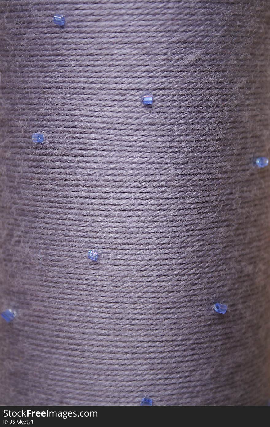 Round texture of grey woolen threads with beads