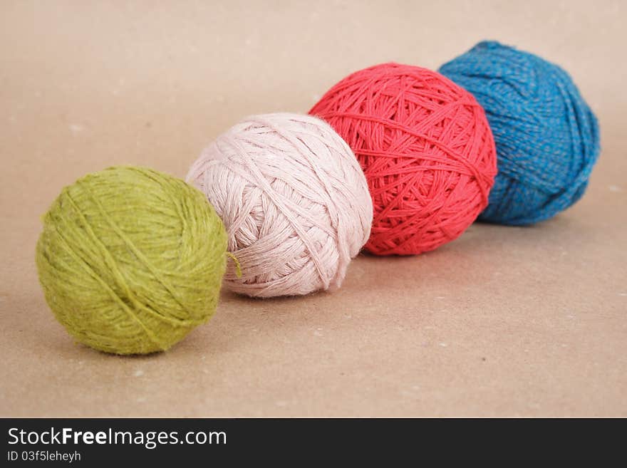 Four multicolored clews on brown paper background