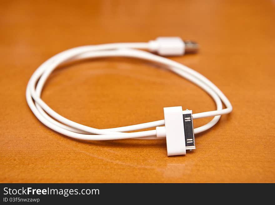 Rolled white USB cable on the desk