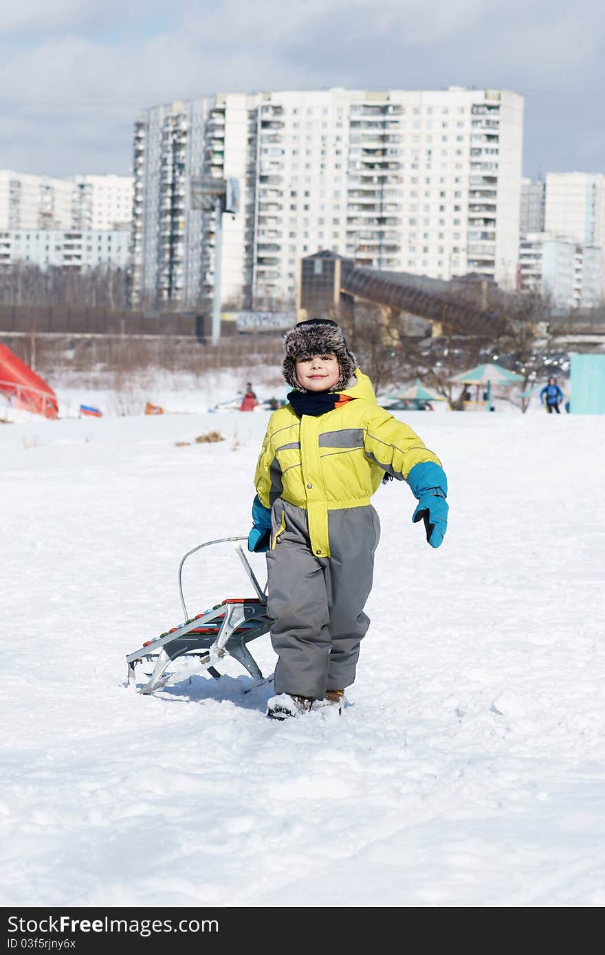 Little happy boy with sled, winter time