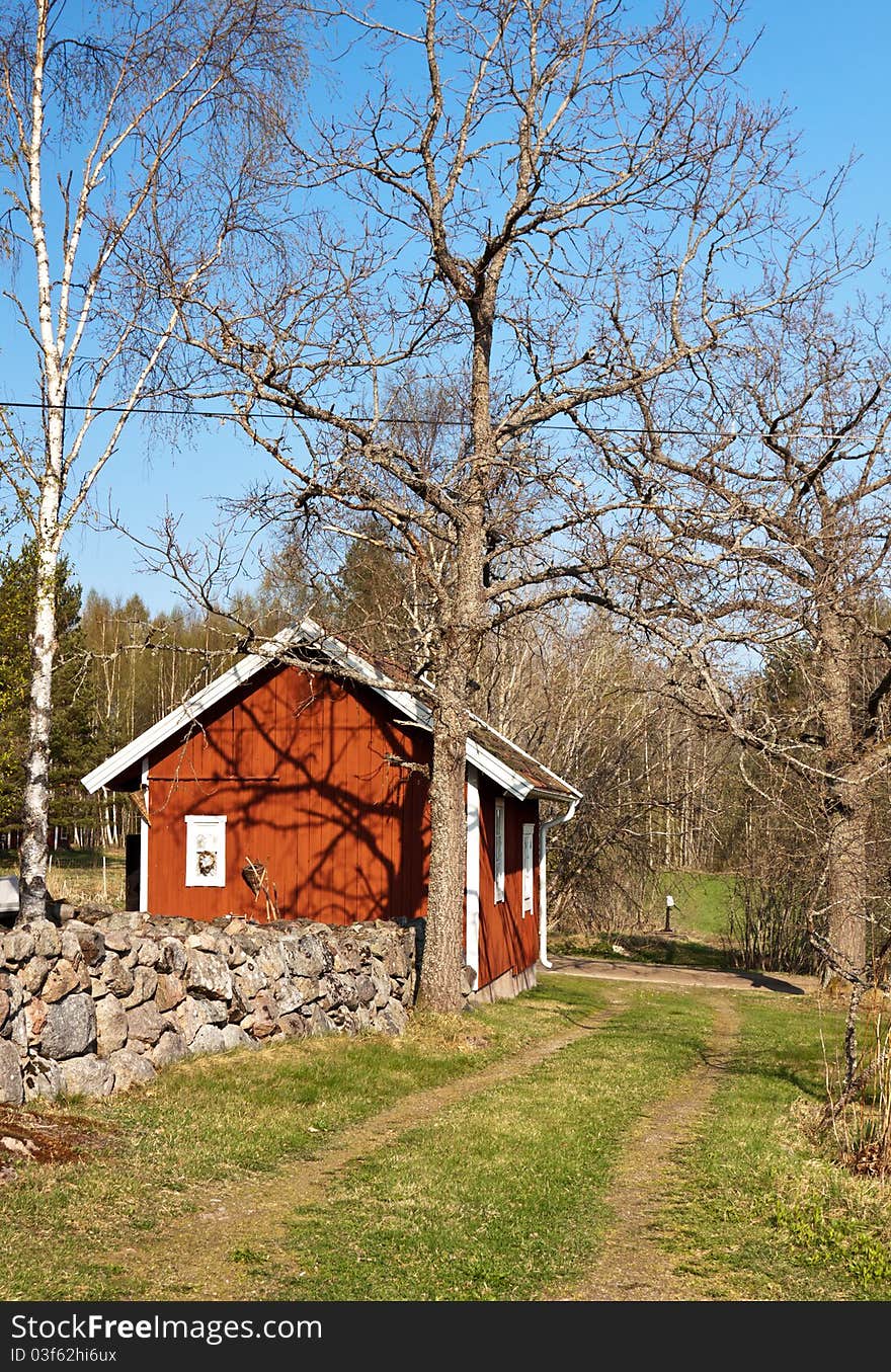 Stone Wall And A Typical Red House In Sweden.