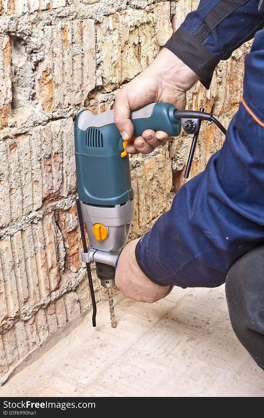 Builder hold perforator and drilling brick wall. Builder hold perforator and drilling brick wall