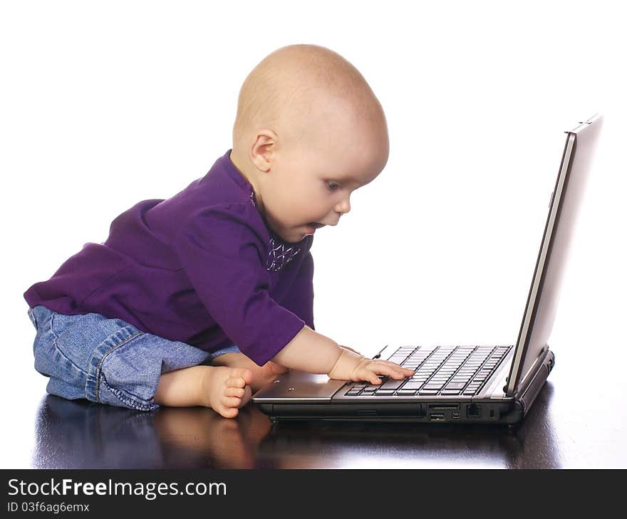 Infant girl looking at the computer as if she has discovered something important. Infant girl looking at the computer as if she has discovered something important