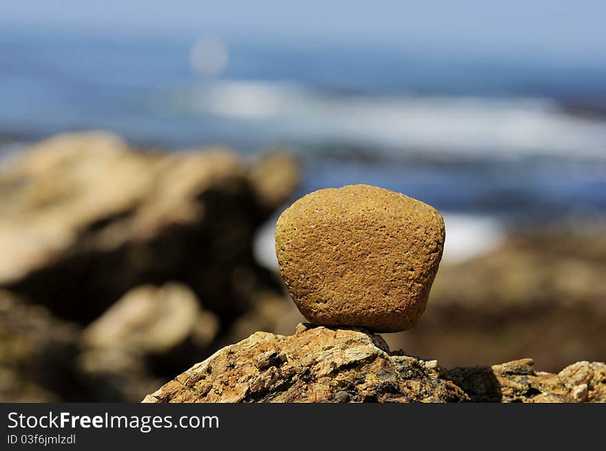 A rock balanced on top of another rock formation on the coast of Newport Beach,CA. A rock balanced on top of another rock formation on the coast of Newport Beach,CA.